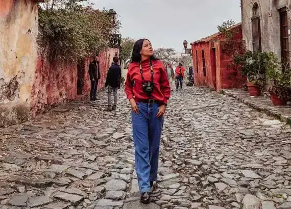 Uma mulher explorando a Calle de los Suspiros, uma atração imperdível para visitar em Colonia del Sacramento em um dia.