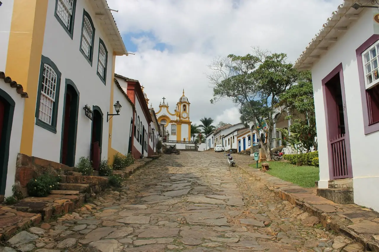 Imagem de uma rua de pedra e casas coloridas em Tiradentes, a cidade eleita pela departures a mais bonita do Brasil 