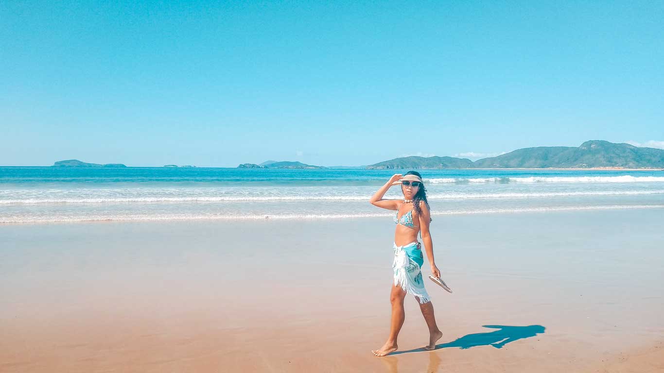 Mulher caminhando nas areias da Praia de Geribá em Búzios