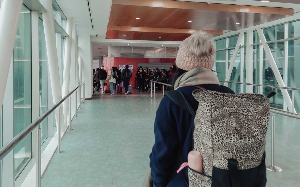 Mulher com uma mochila na costa caminhado para imigração uruguaia.