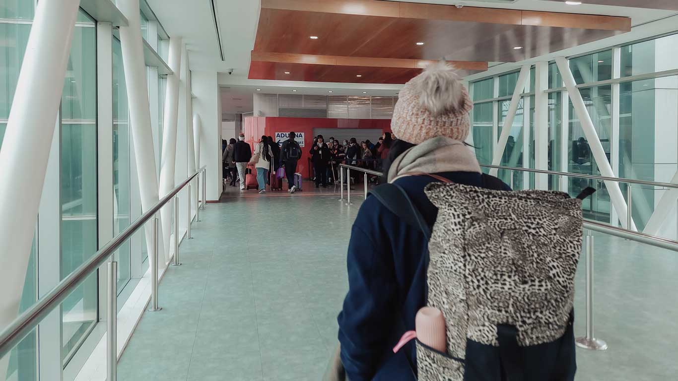 Mulher com uma mochila na costa caminhado para imigração uruguaia.