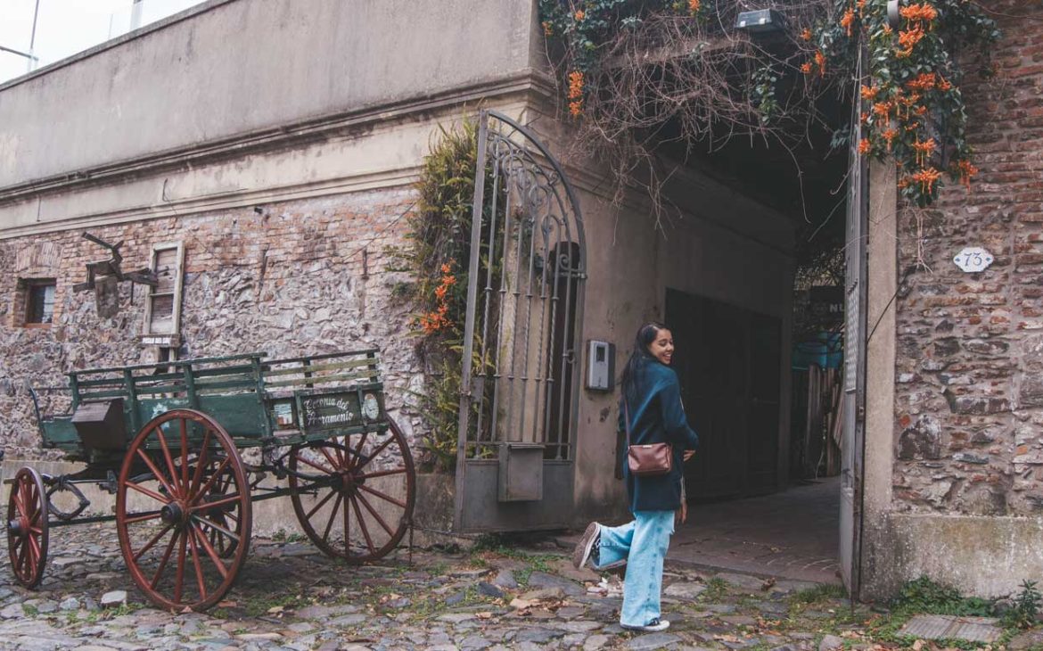 Uma mulher posando para uma foto em um cenário típico de Colonia del Sacramento.