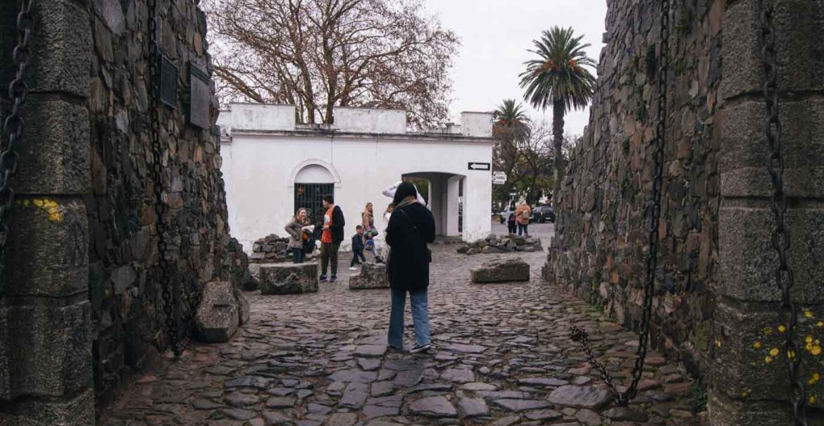 Mulher atravessando o Portón de Campo em Colonia del Sacramento.