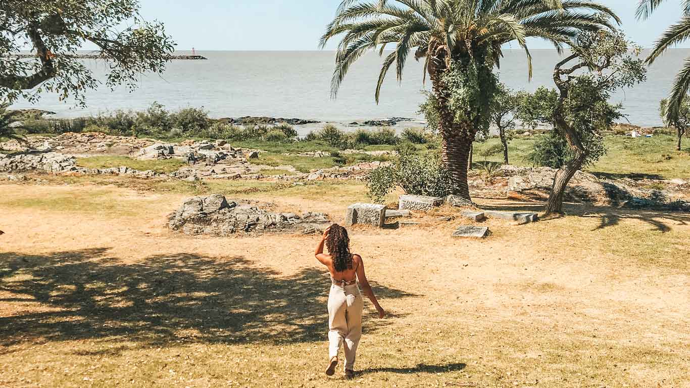 Uma mulher caminhando em direção ao Rio de la Plata em Colonia del Sacramento.