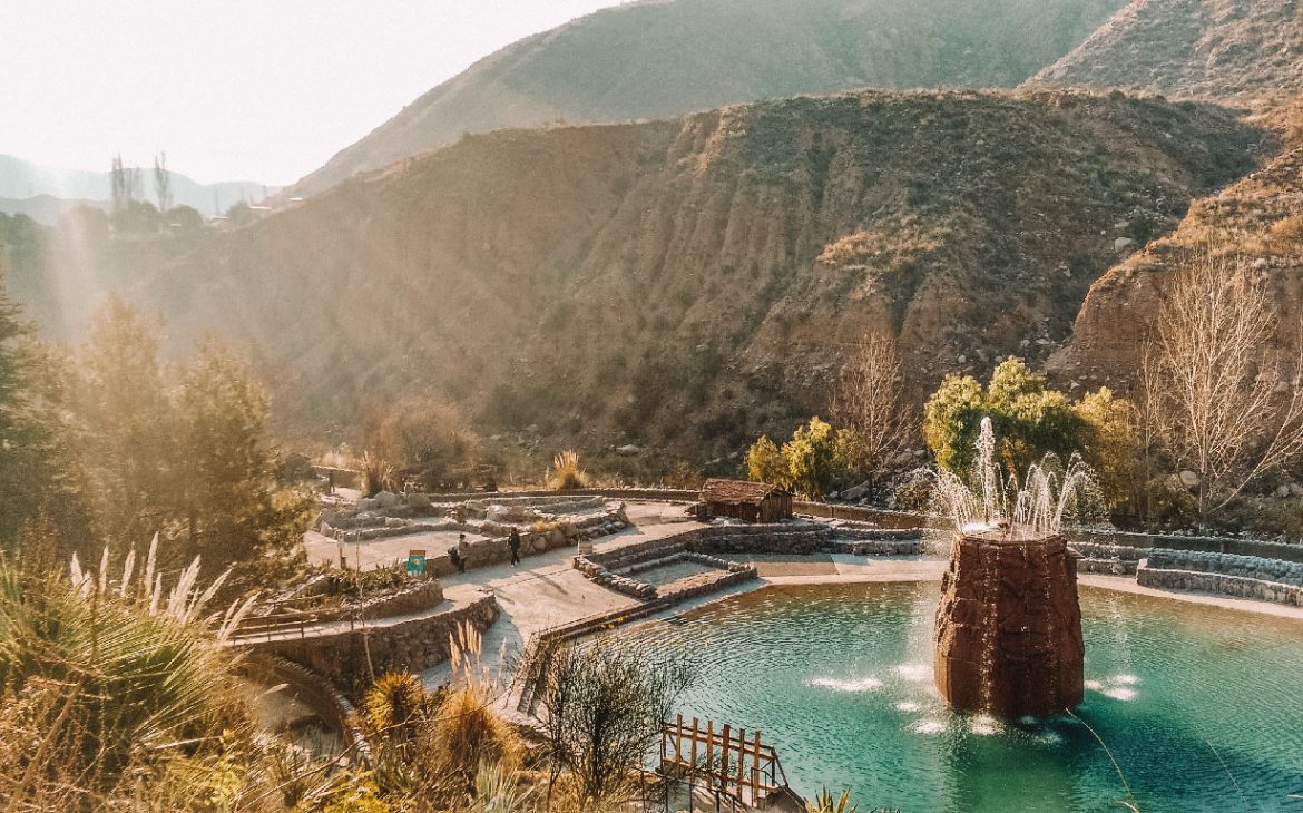 Piscina termal com águas azuis e vista para as montanhas nas Termas de Cacheuta em Mendoza.