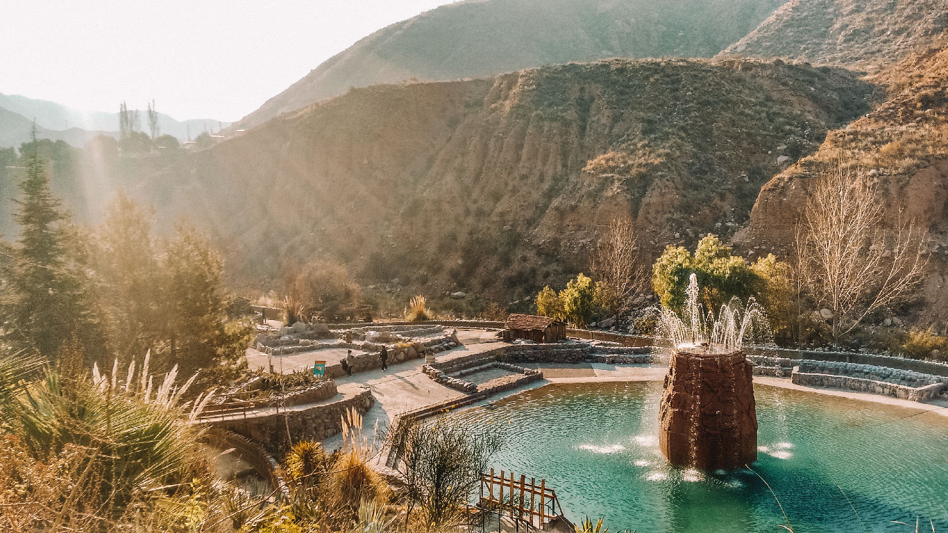 Piscina termal com águas azuis e vista para as montanhas nas Termas de Cacheuta em Mendoza.