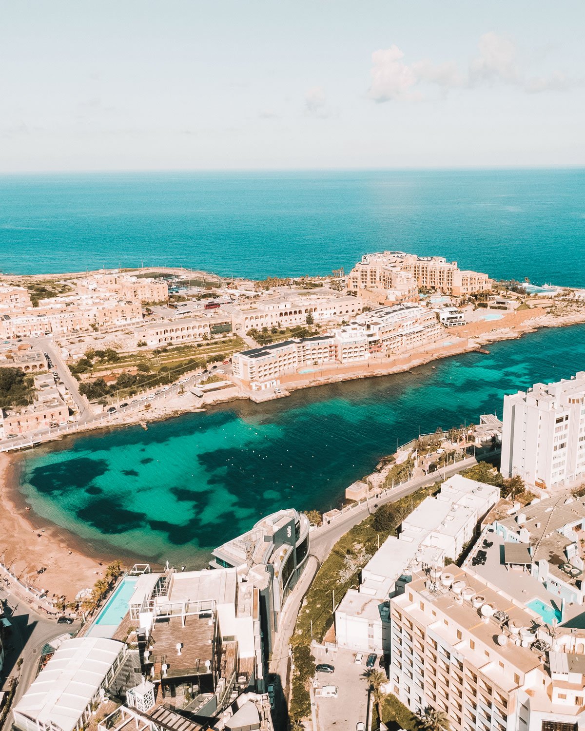 Vista do alto, St. Julian's em Malta revela uma paisagem encantadora, onde os edifícios de cores claras se erguem contra o mar azul.